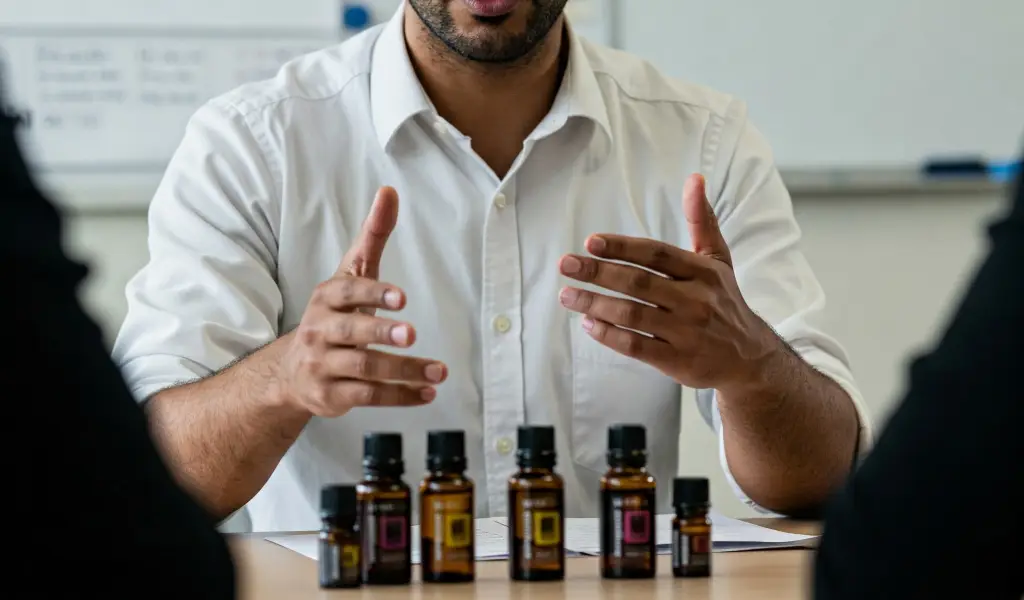 Hombre joven explicando aceites esenciales en un entorno educativo